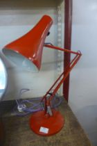 A red metal anglepoise desk lamp