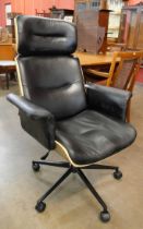 An Eames style simulated rosewood and black leather revolving desk chair
