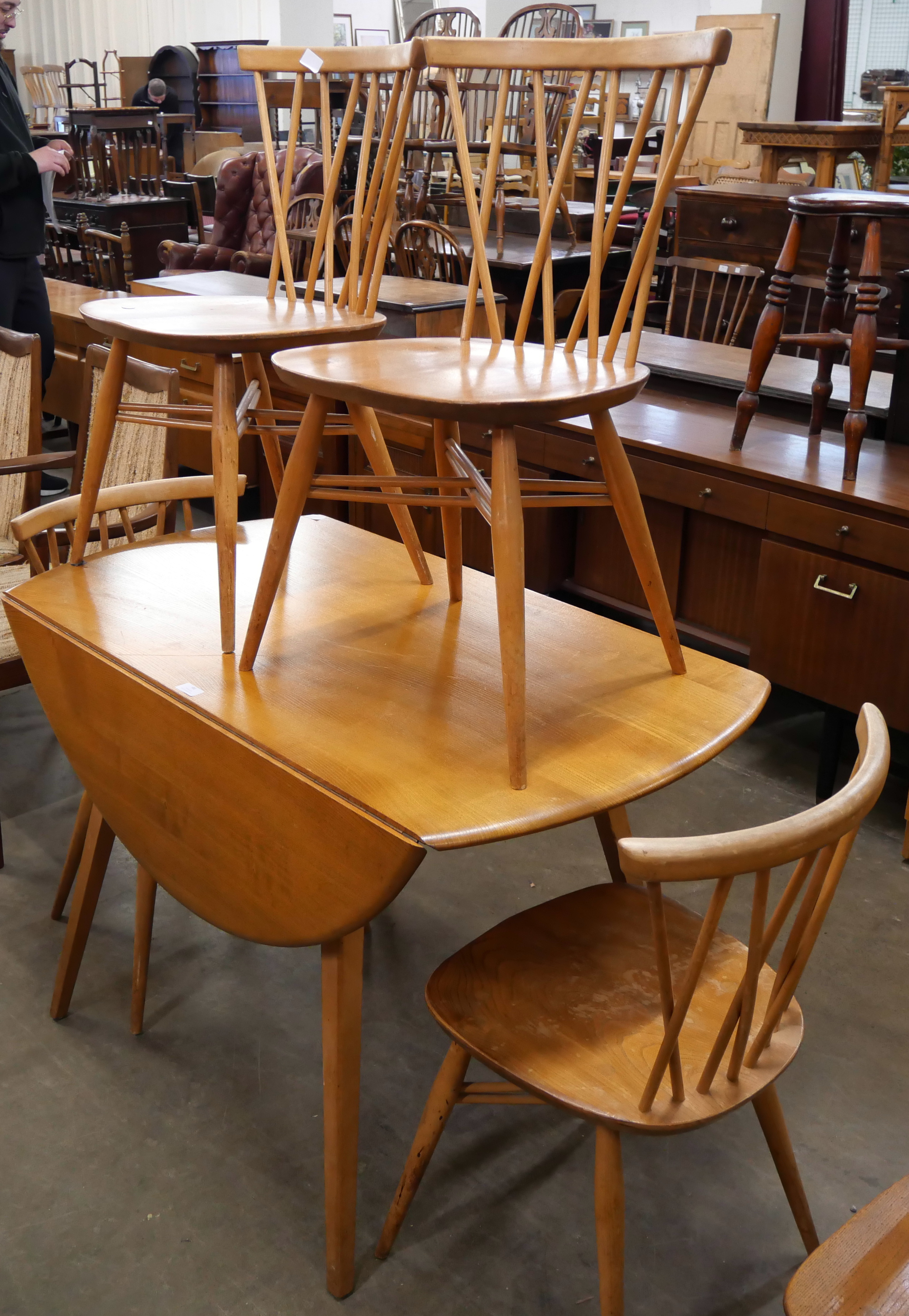 An Ercol Blonde elm and beech Windsor drop leaf table and four candlestick back chairs