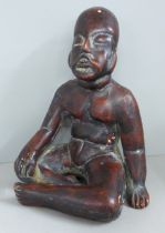 A terracotta figure of a native, seated, 19cm