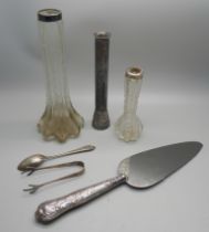 a pair of silver sugar bows, a silver spoon, two silver topped bud vases, a silver handled cake