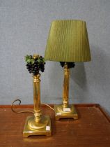 A pair of brass lamps with grape decoration