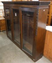 A late Victorian carved oak three door bookcase