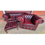 An oxblood red leather Chesterfield three piece lounge suite, comprising, settee, club chair and