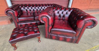 An oxblood red leather Chesterfield three piece lounge suite, comprising, settee, club chair and