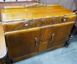 An early 20th Century carved oak dining suite, comprising; a draw-leaf table, four chairs and a