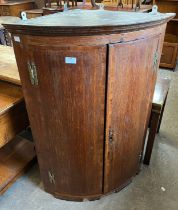 A George III oak wall hanging corner cupboard