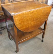 An oak drop-leaf trolley and occasional table
