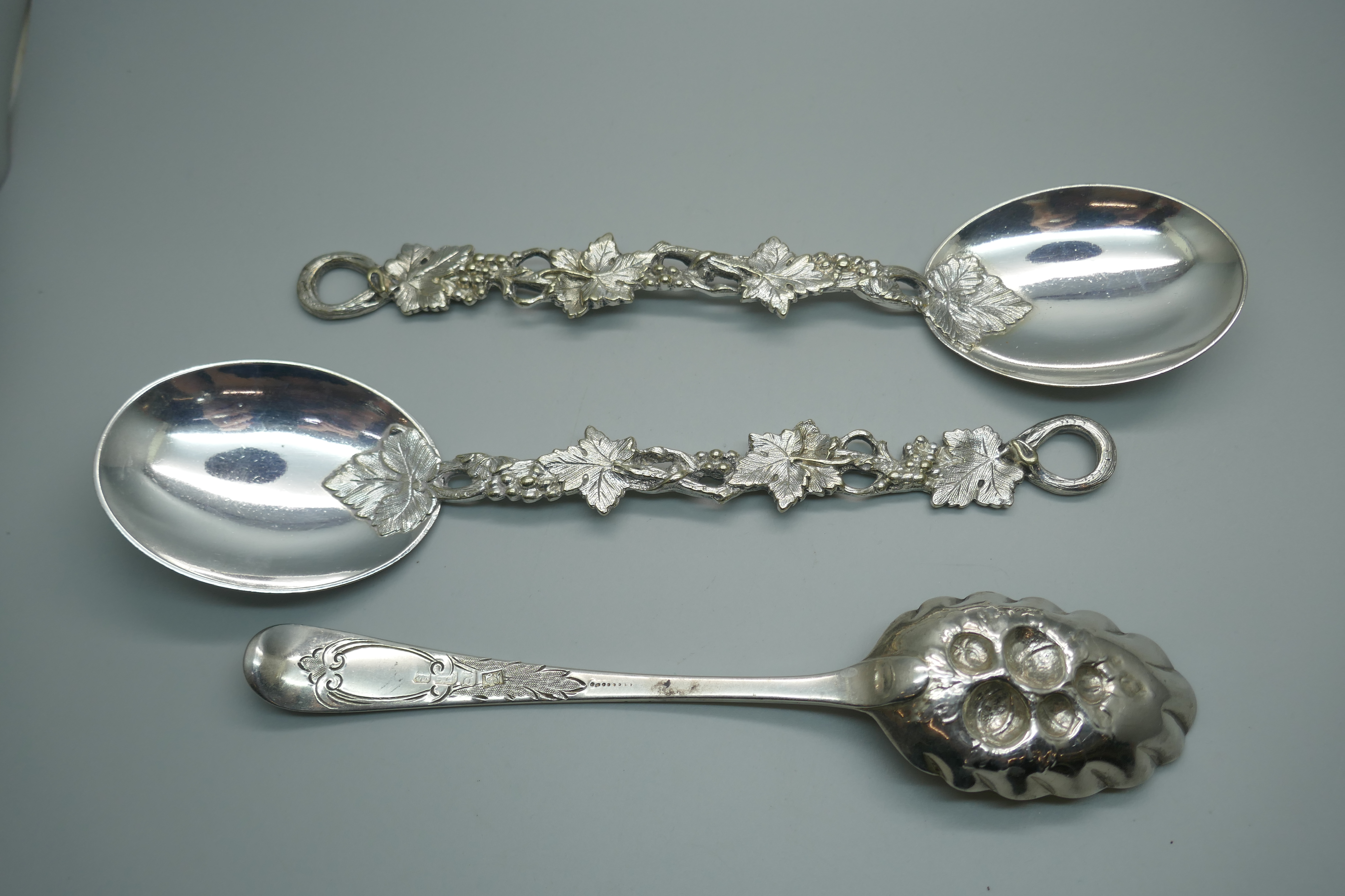 A George III silver berry spoon, London 1782, 65g, and two vine detail serving spoons - Image 2 of 3