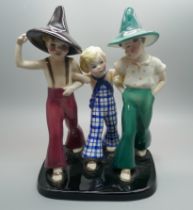 A 1930s Goldscheider figure group of two young boys, wearing pointed hats, striding arm in arm