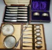 Two small circular silver dishes, two boxed silver napkin rings, boxed set of six silver handled