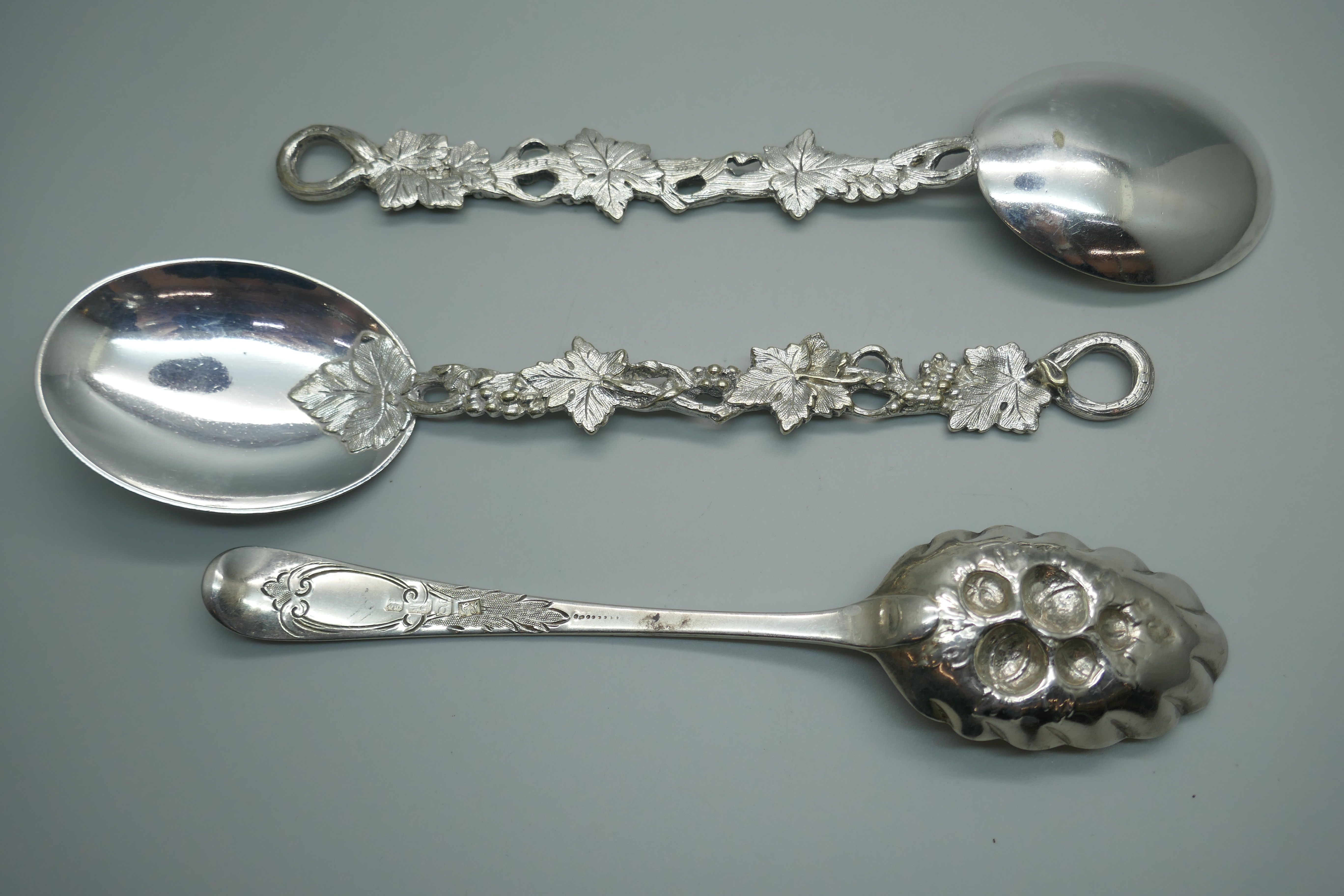 A George III silver berry spoon, London 1782, 65g, and two vine detail serving spoons - Image 3 of 3