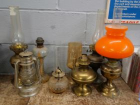 Seven oil lamps, two matching, one with bright orange glass shade and a spare top **PLEASE NOTE THIS