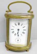 A French 19th Century gilt brass and glass oval cased carriage clock, with alarm