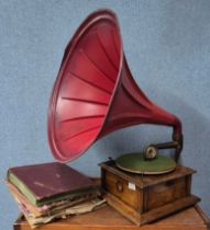 A Beltons wind-up table top gramophone with large red metal speaker horn, with records, handle and