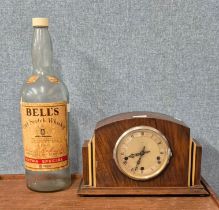 An Art Deco oak mantle clock and a large Bell's Whisky bottle