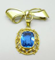 An 18ct gold pendant set with a blue stone, on a yellow metal brooch mount in the form of a bow, 6.