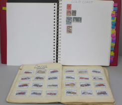 A stamp album containing world stamps, a collection of vintage comic postcards and a notebook