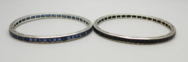 Two white metal bangles set with blue glass stones