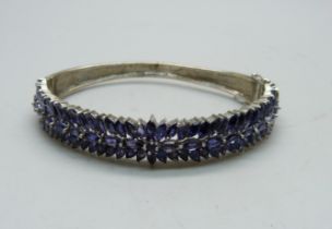 A silver bangle set with purple stones, a/f dented and split, 25g