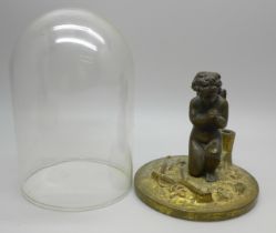 A small bronze figure of a cherub prayer under an associated glass dome