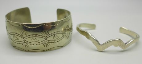 A Navajo style bangle with bear and feather decoration, marked C Sterling, 34g, and silver bangle in