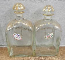 A pair of 19th Century glass decanters with gilded decoration to the shoulders, neck and top, each