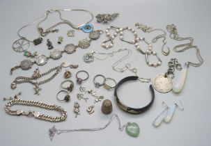 A collection of silver rings, pendants and bracelets including a charm bracelet with loose
