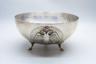 An 830 silver bowl on three feet and with three circular panels with double headed eagle, Corinthian