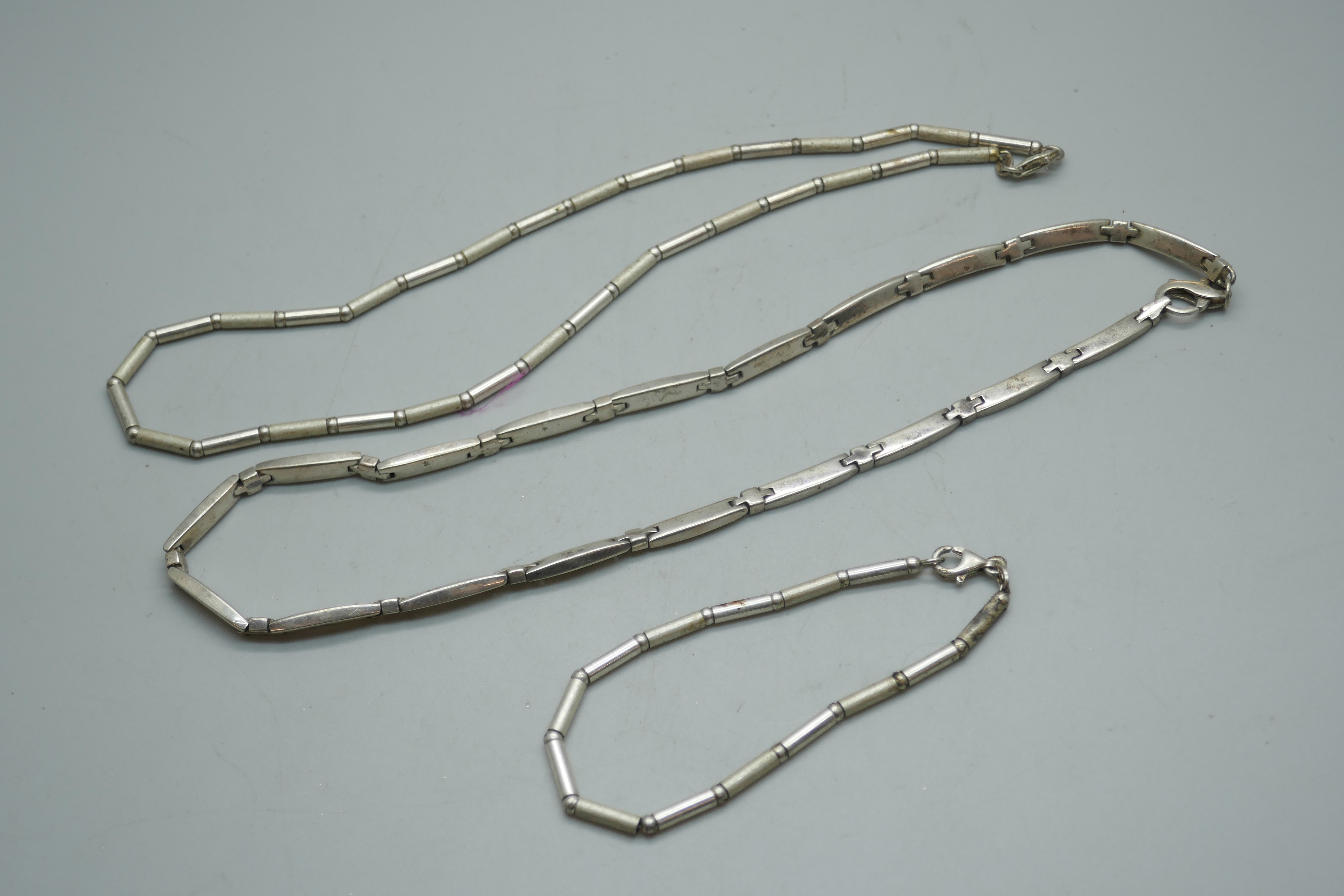 A silver bracelet and necklace set and another silver necklace, 66g