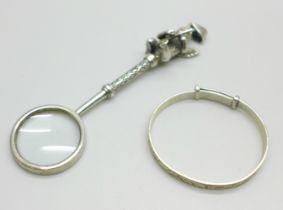 A child's silver bangle and a novelty magnifying glass pendant