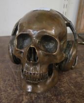 A figure of a bronze skull wearing headphones