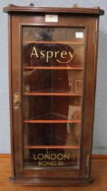 A mahogany display cabinet bearing Asprey inscription