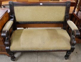 An early 20th Century carved mahogany and fabric upholstered settle