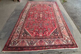 An eastern hand knotted red ground rug, 333 x 229cms