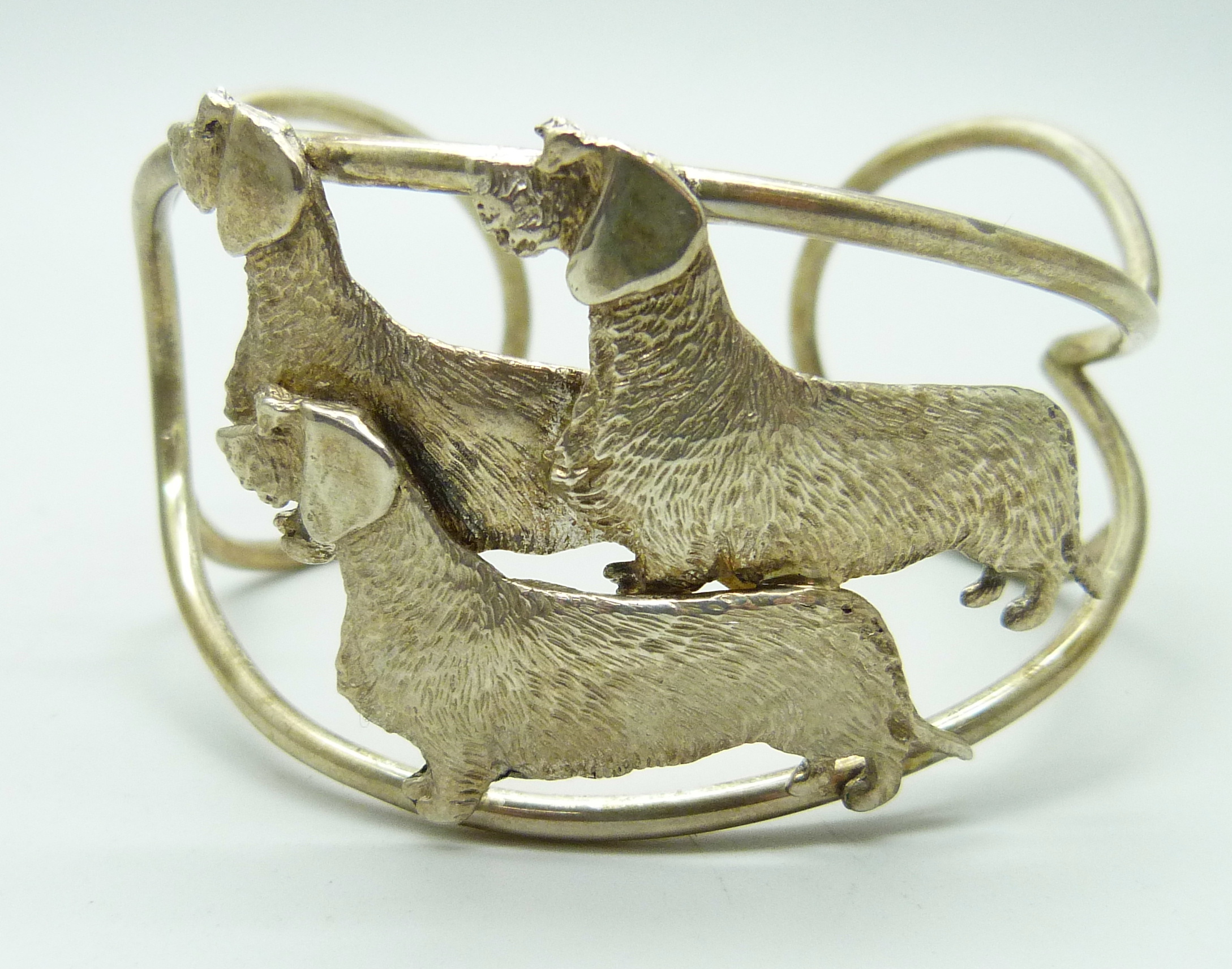 A silver cuff bangle with three wired hair dachshund detail