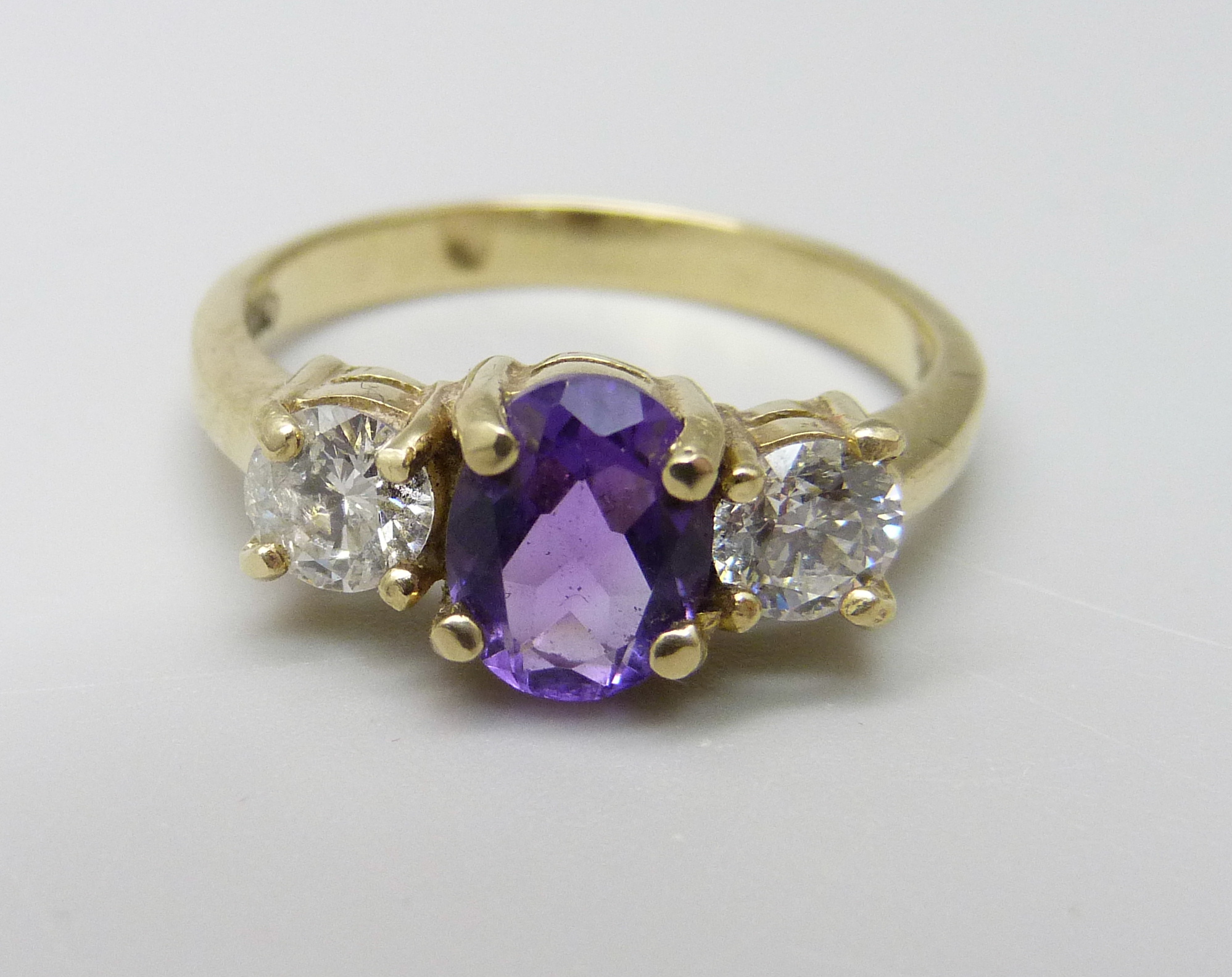 An 18ct gold, amethyst and diamond three stone ring, approximately 90ct weight, 3.9g, Q