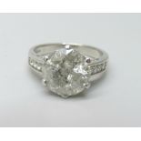 A hallmarked platinum solitaire diamond ring with diamond set shoulders, 3.80cts, 6.2g, M