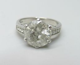 A hallmarked platinum solitaire diamond ring with diamond set shoulders, 3.80cts, 6.2g, M