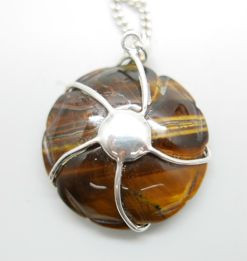 A carved silver mounted tigers eye pendant on a silver chain and a pair of tigers eye earrings, - Bild 3 aus 3