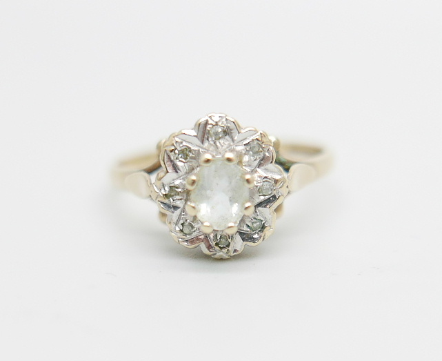 A 9ct gold ring set with a clear central stone and diamond chip halo, 2.2g, O