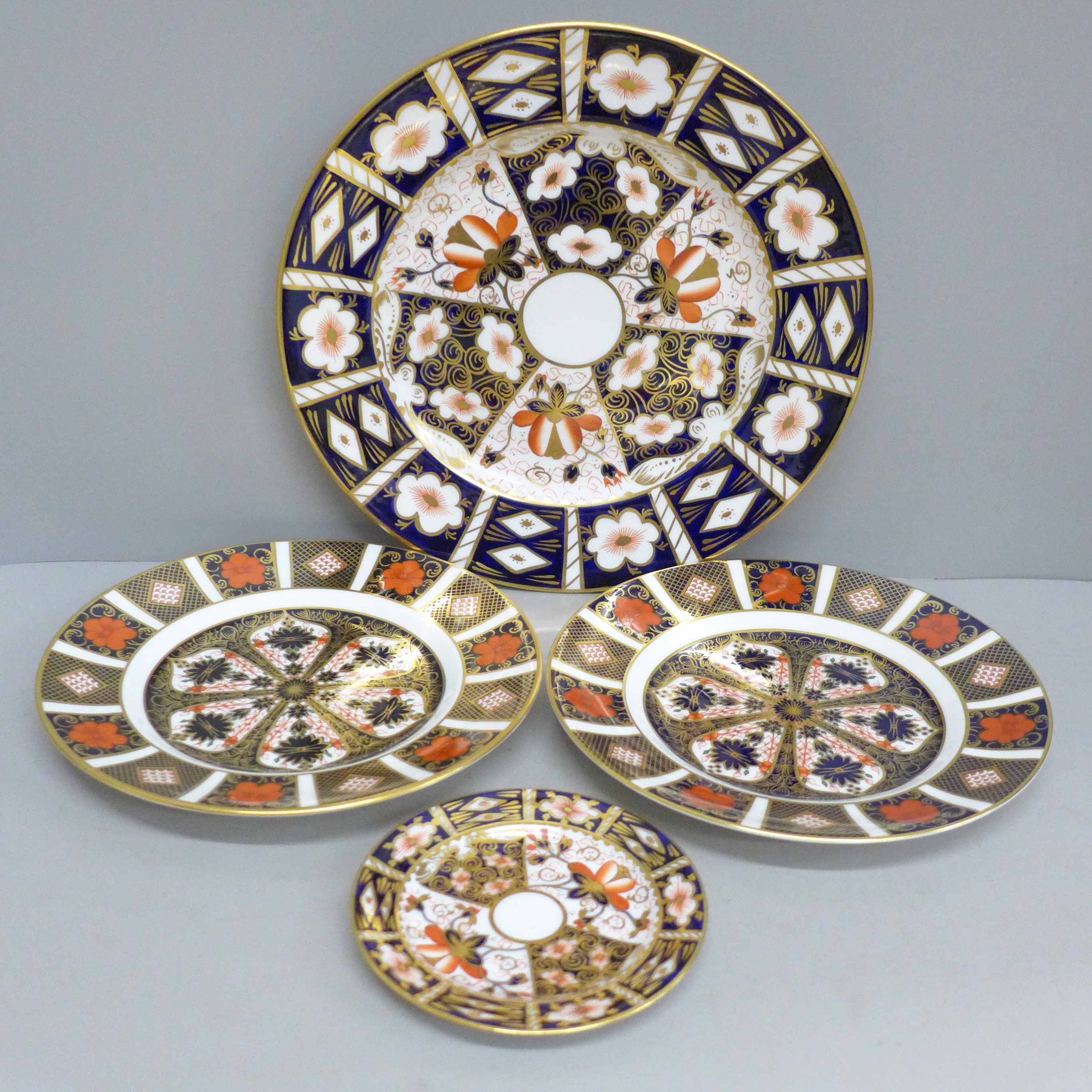 Four items of Royal Crown Derby, a 2451 dinner plate, pin dish and a pair of 1128 side plates (one