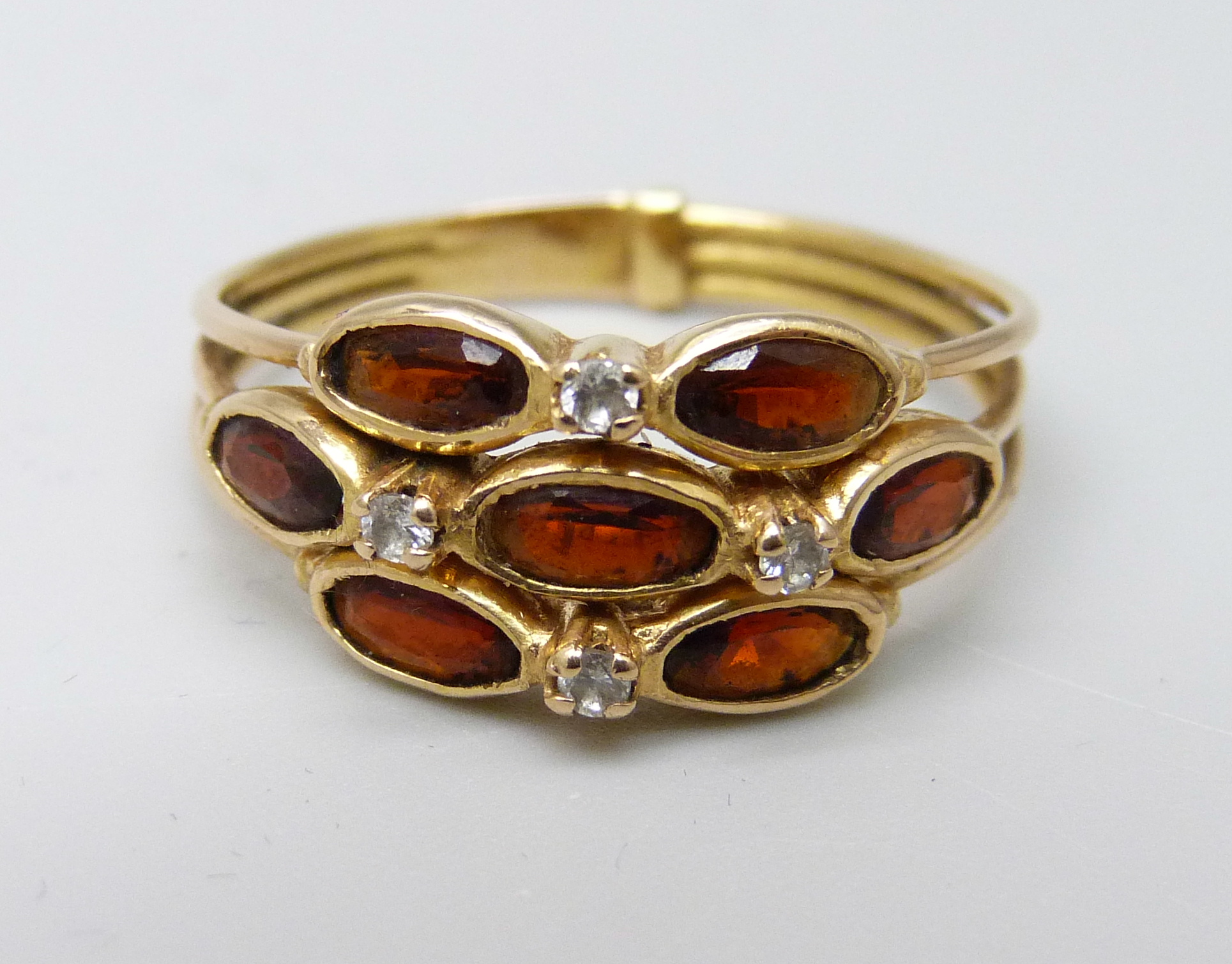A yellow metal garnet and diamond cluster ring, 3.6g, T, continental control mark on the outside