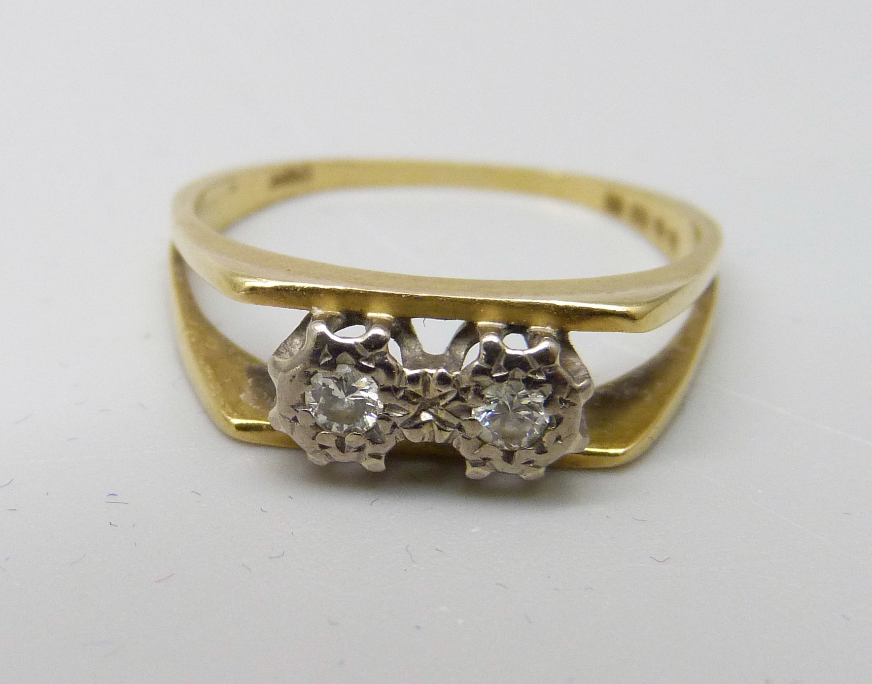 An 18ct gold and two stone diamond ring, 2.2g, J