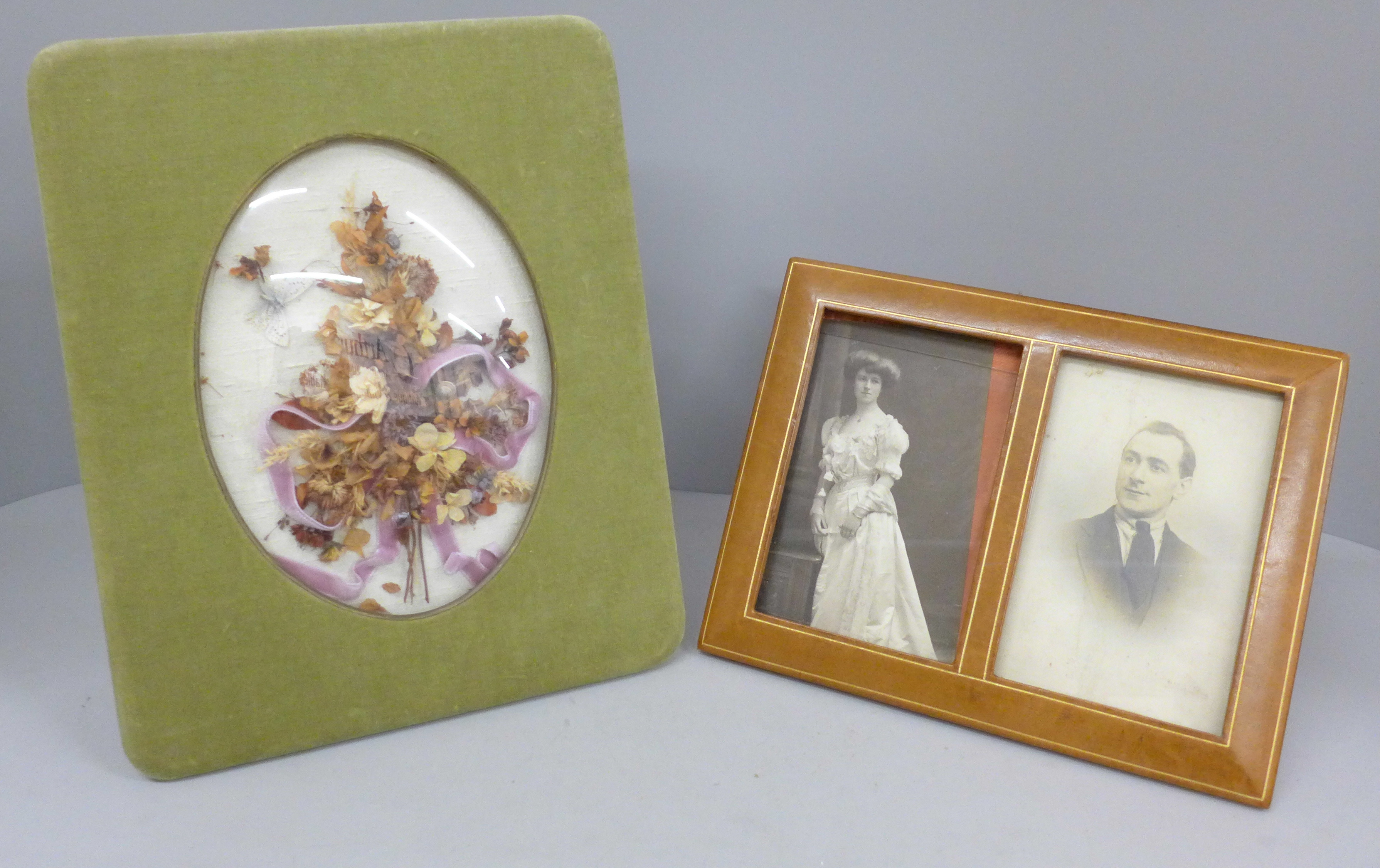 An Edwardian dried flower display under a convex glass with silk photograph frame and a double