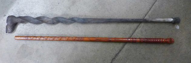 Two novelty walking canes, one dated 1989 and carved with miners head, miners lamp, pick axe and