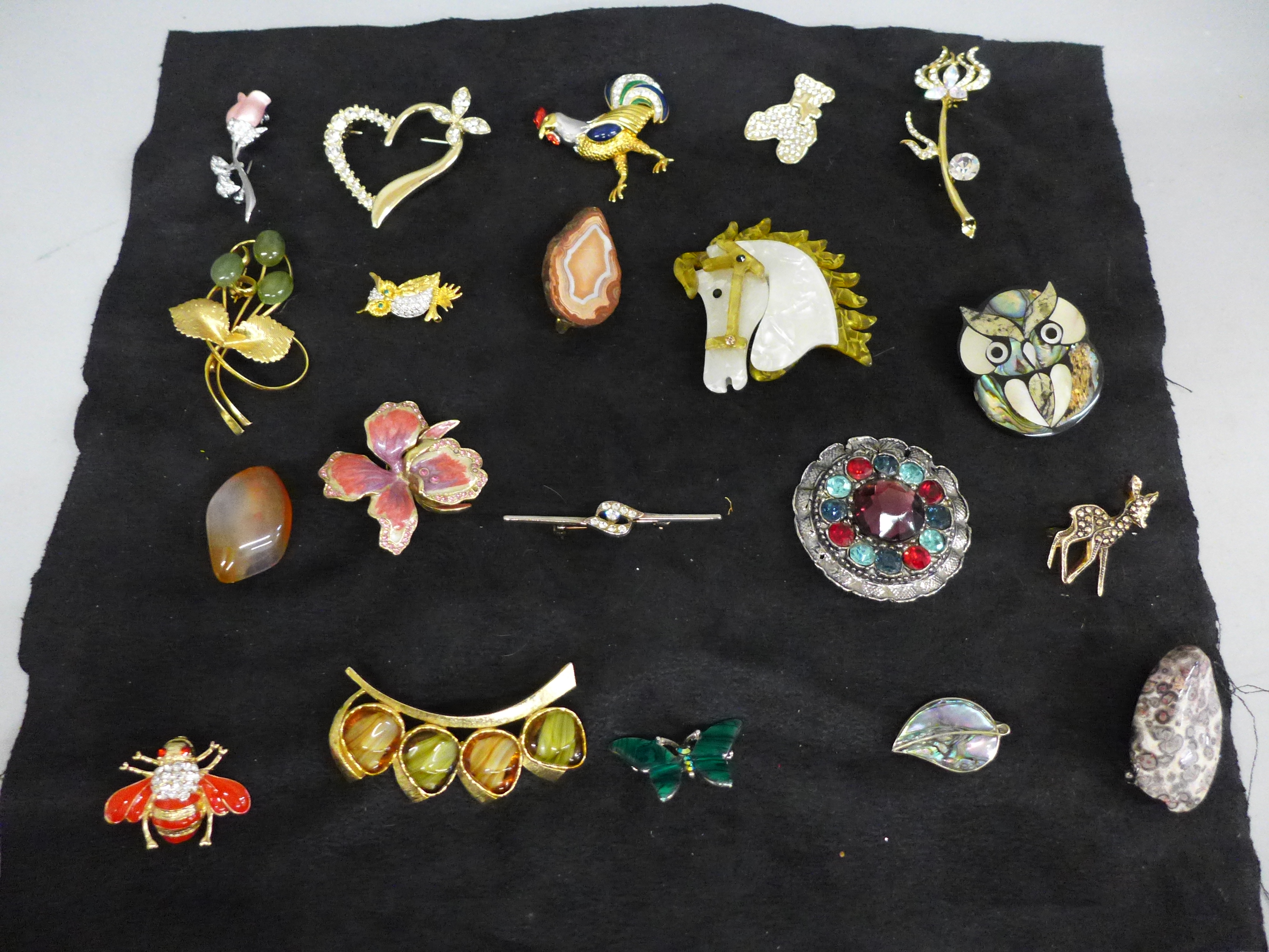 Twenty costume brooches including one silver