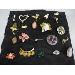 Twenty costume brooches including one silver