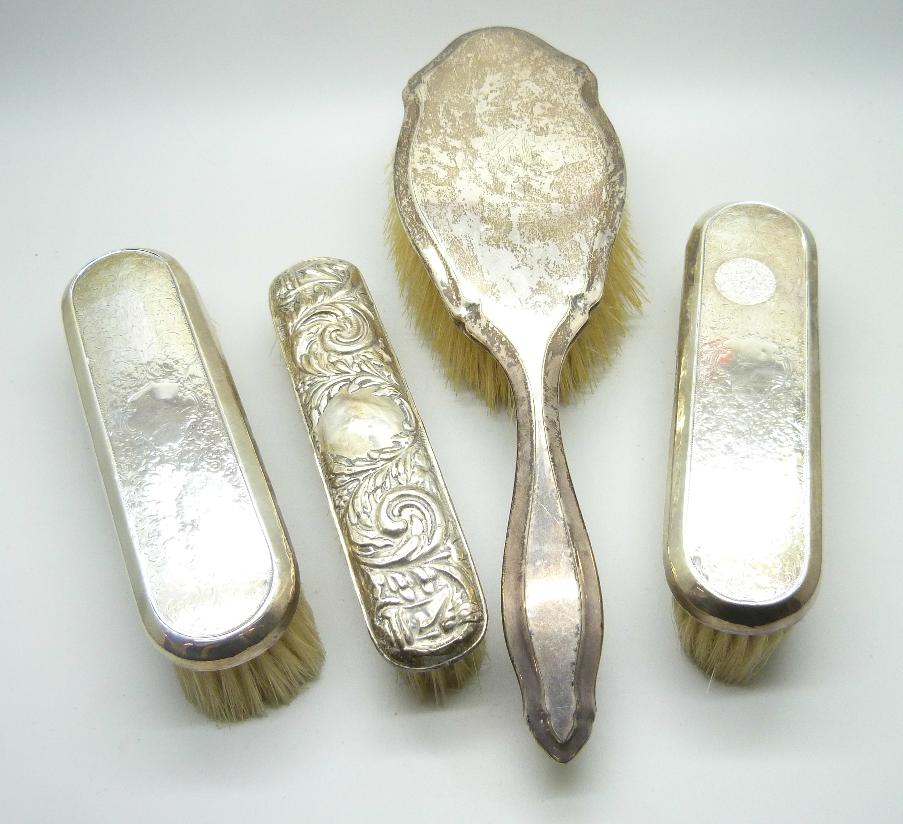 Four silver backed brushes