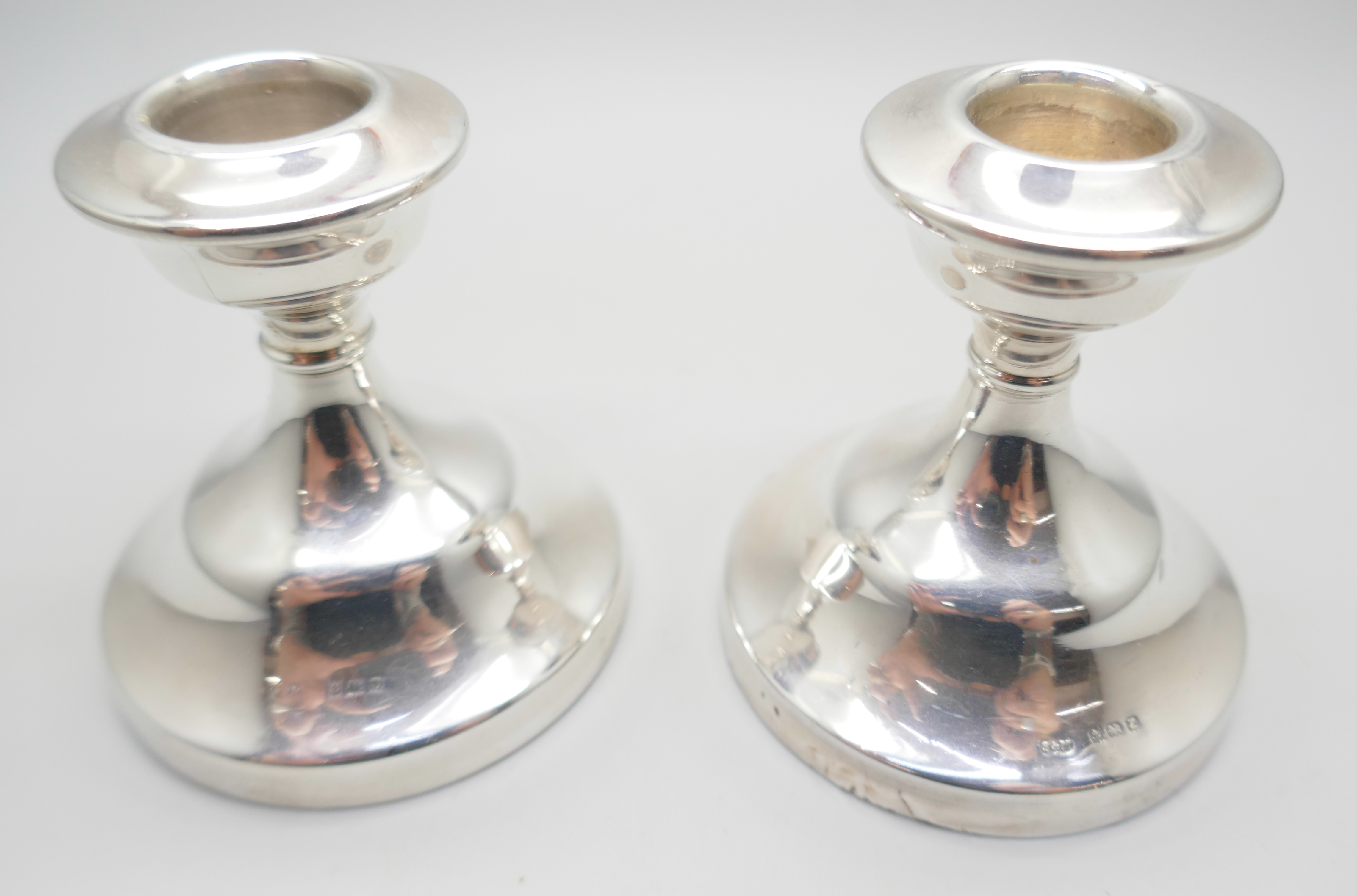 A matched pair of silver dwarf candlesticks